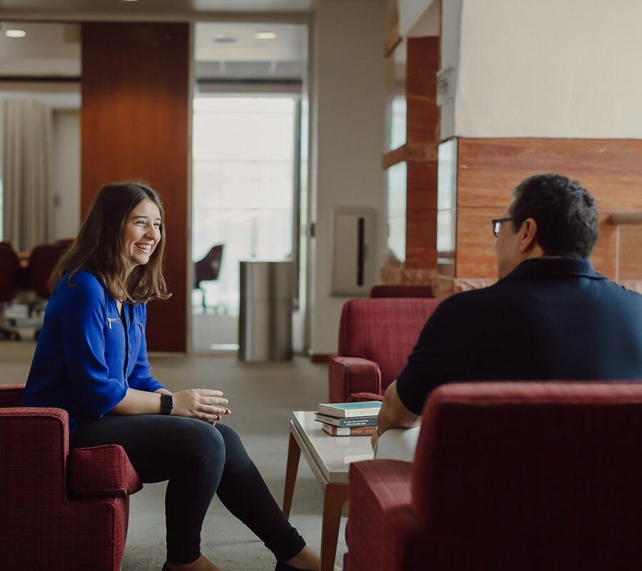 a student sitting in the library meeting with an admissions counselor